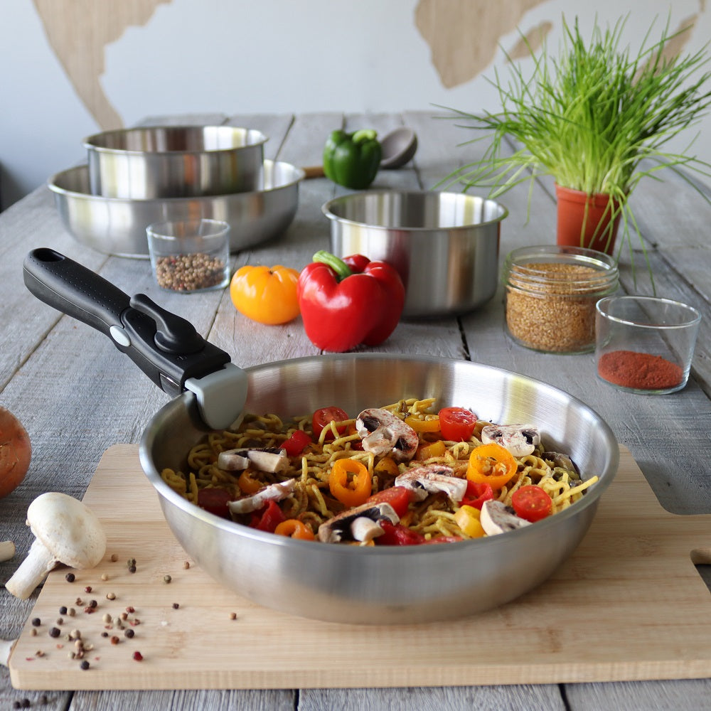 Poêle induction en acier inoxydable sur une table avec des légumes