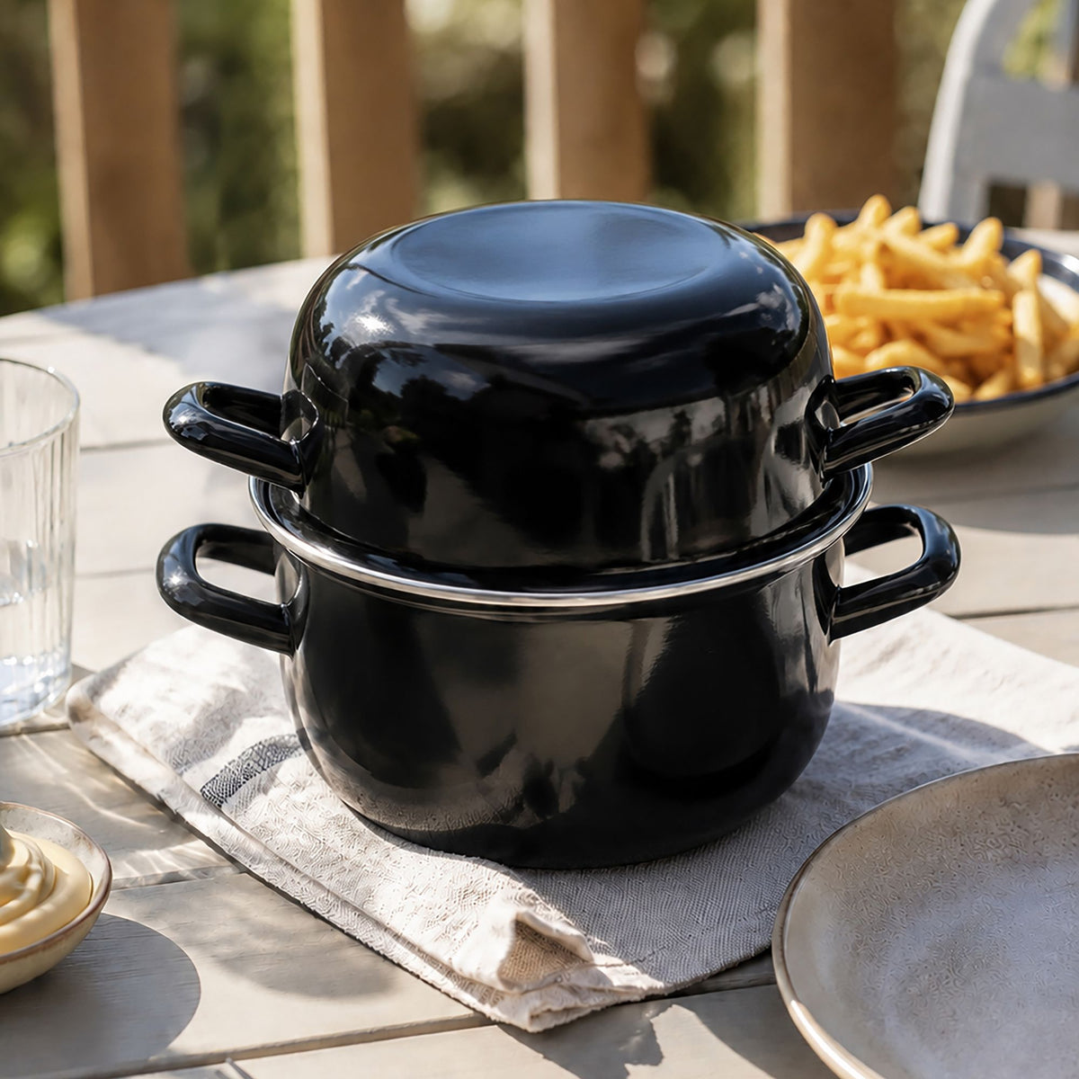 Marmite à moules en acier émaillé noir 18 cm avec couvercle, présentée sur table extérieure avec frites