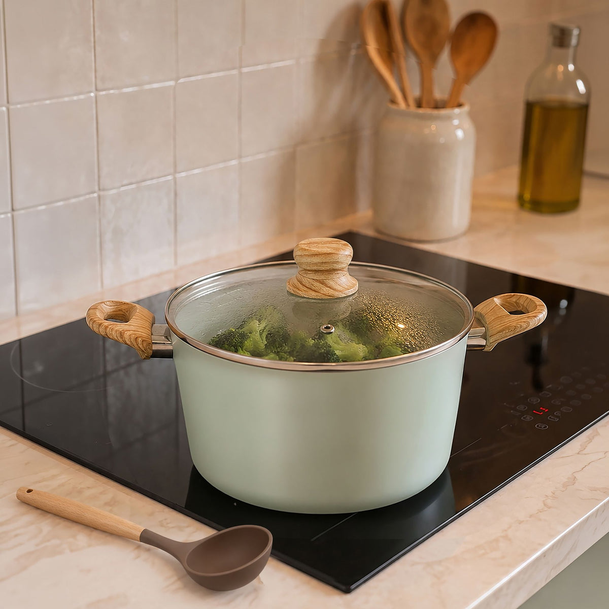 Casserole céladon du set Colorama 13 pièces avec couvercle en verre et poignées bois, en cuisson sur plaque induction