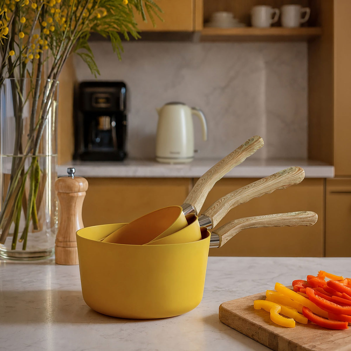 Set de 3 casseroles jaunes Colorama avec manches bois sur plan de travail marbre, cuisine moderne