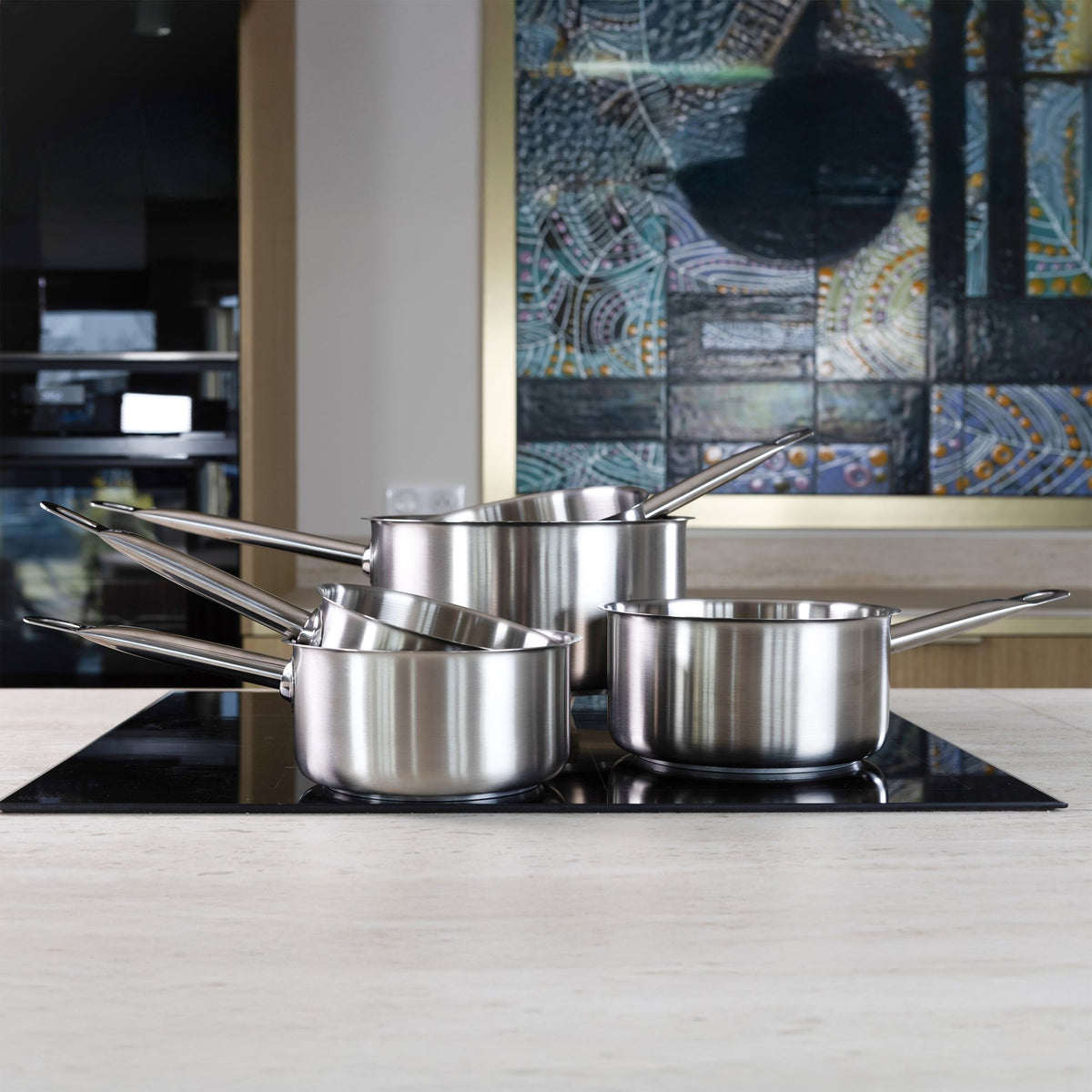 Set de 4 casseroles professionnelles en acier inoxydable empilées sur plaque induction, vue de face
