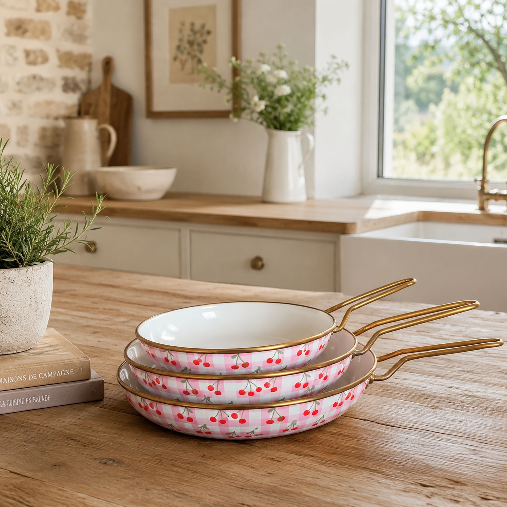 Lot de 3 poêles Vichy Cerise en acier émaillé rose à motif cerises, empilées sur table en bois dans cuisine campagne