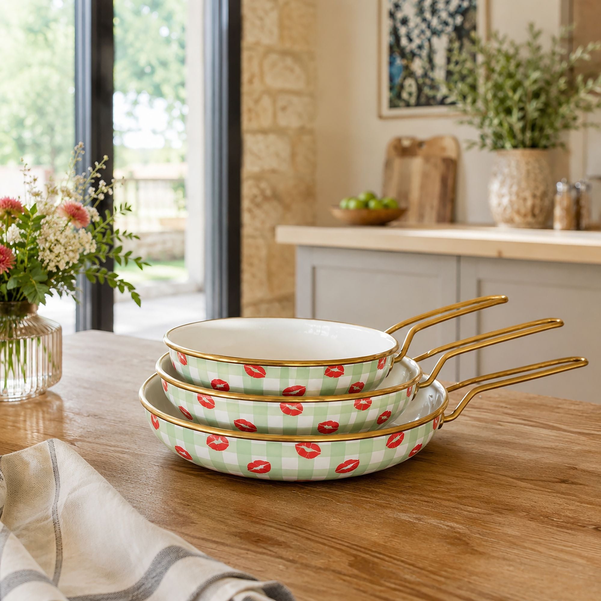 Lot de 3 poêles Vichy acier émaillé motif vichy vert et bisous rouges, empilées sur table en bois