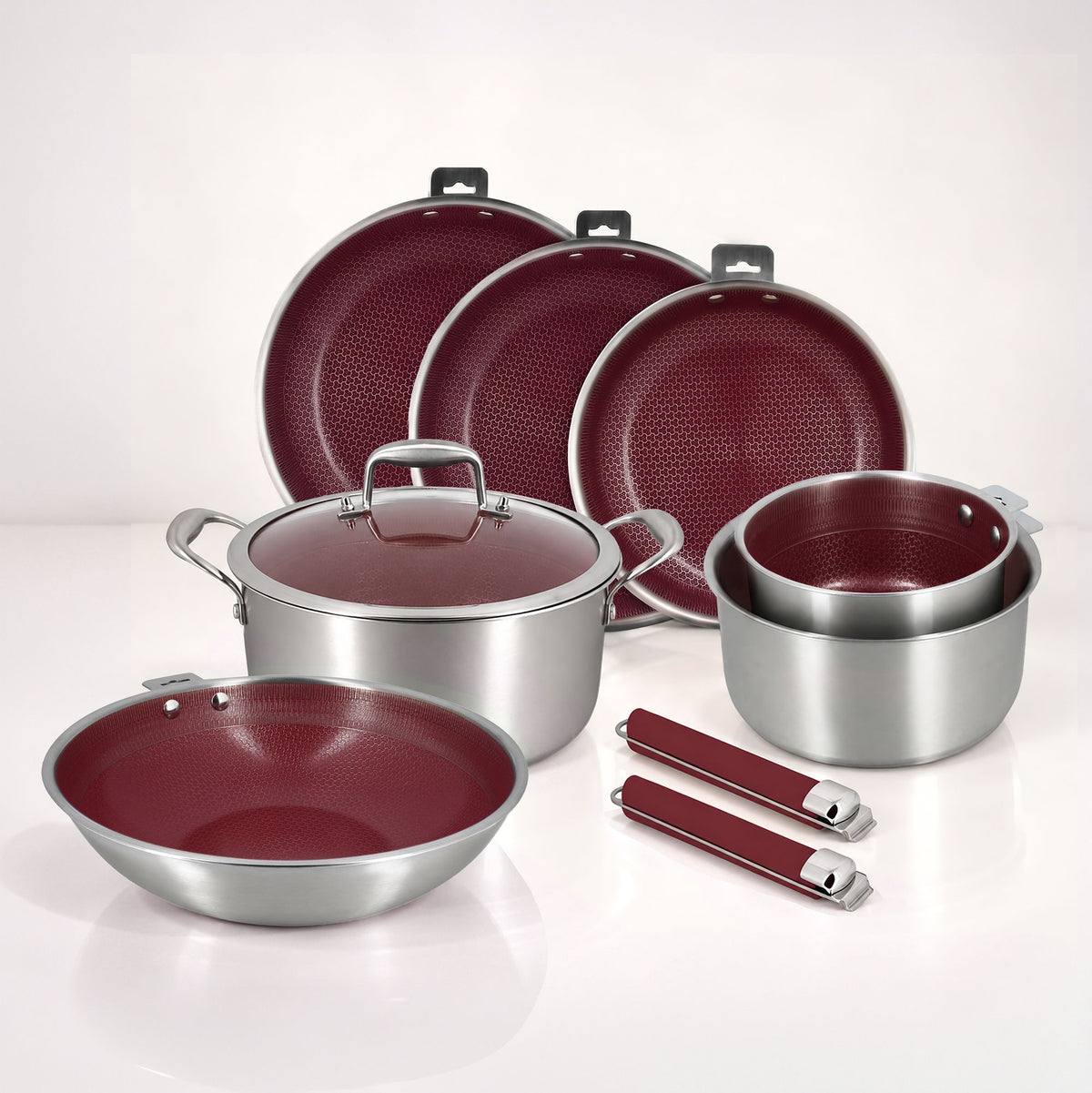 Vue d'ensemble batterie de cuisine Aglaé 10 pièces acier inoxydable, intérieur bordeaux antiadhésif, avec poêles casseroles et maniques