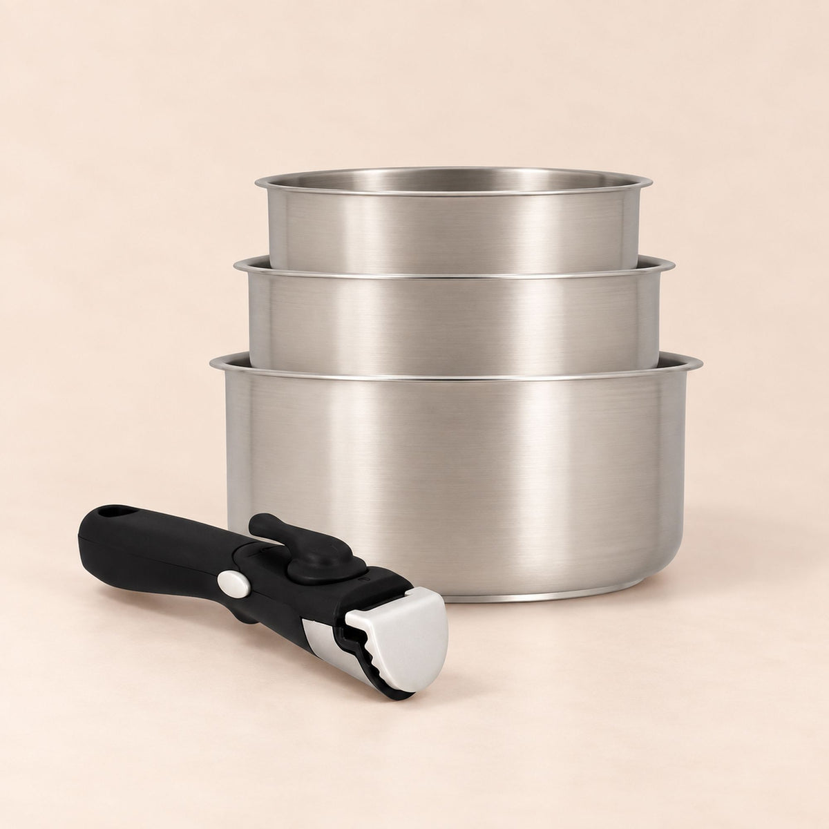 Set de 3 casseroles Iris Inox 16, 18 et 20 cm empilées avec poignée amovible noire et blanche au premier plan