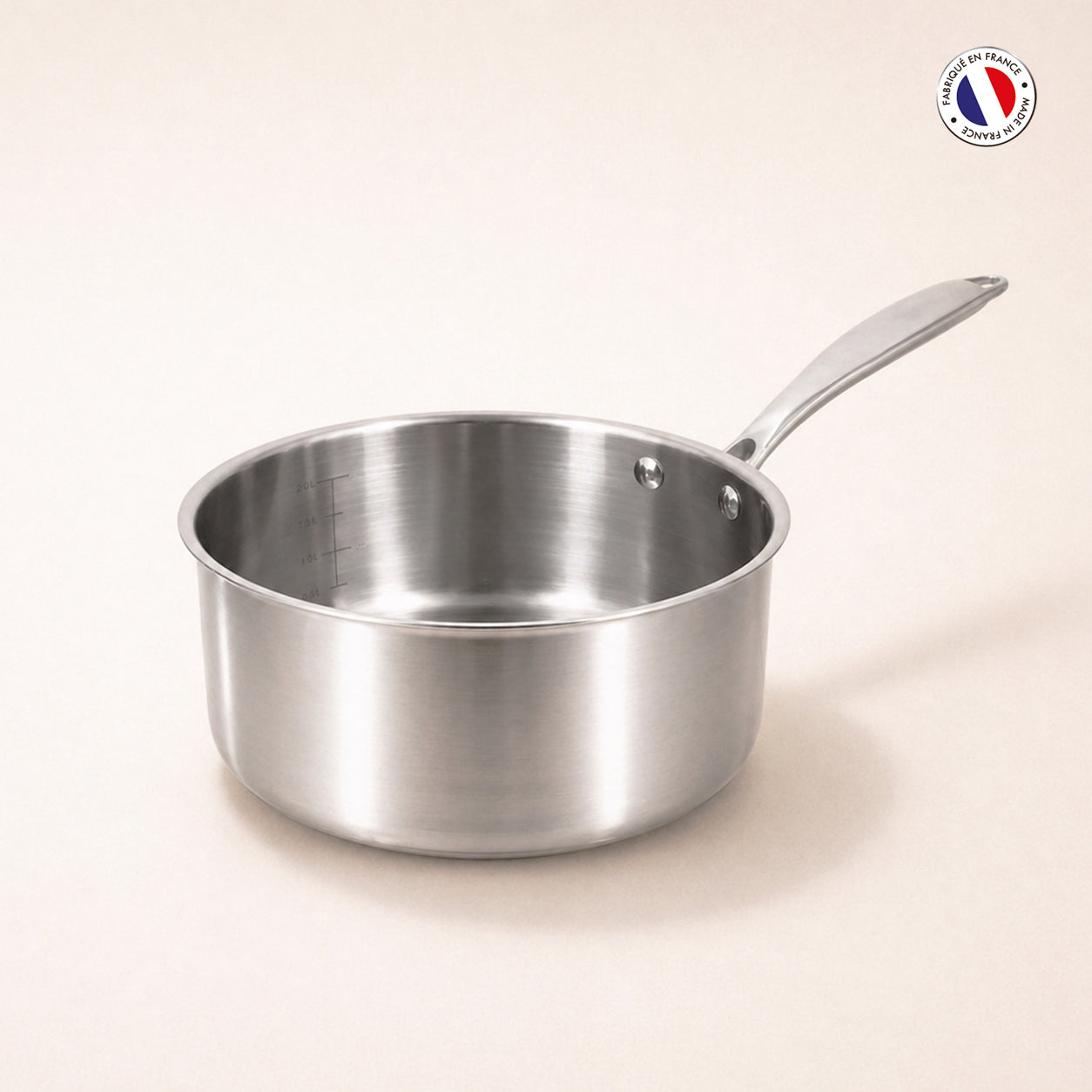 Casserole Triply Menastyl 18 cm en acier inoxydable triple couche, vue de trois quarts sur fond beige clair
