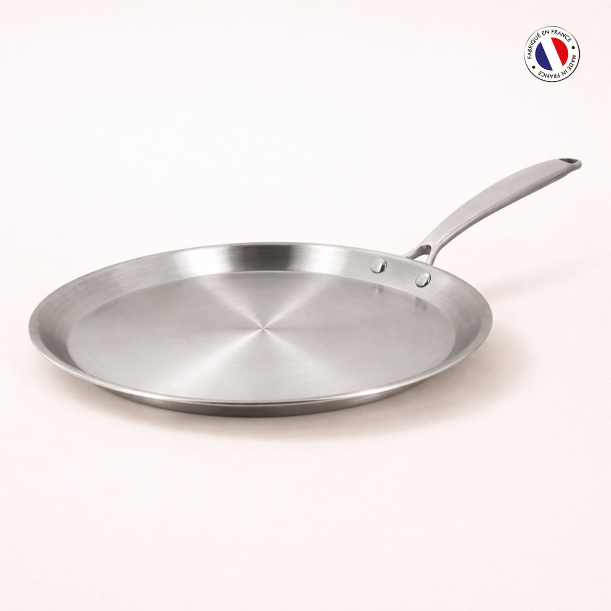 Crêpière Triply 28cm en acier inoxydable triple couche Menastyl, vue de trois quarts avec manche riveté