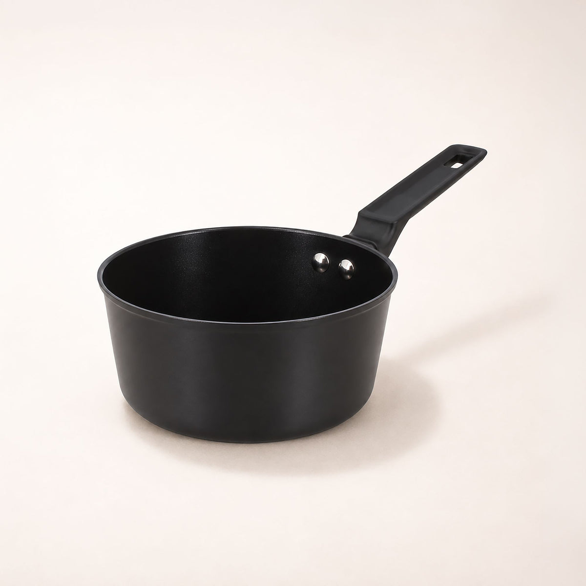 Casserole First 16 cm en aluminium noir avec revêtement antiadhésif, vue intérieure avec billes d'eau