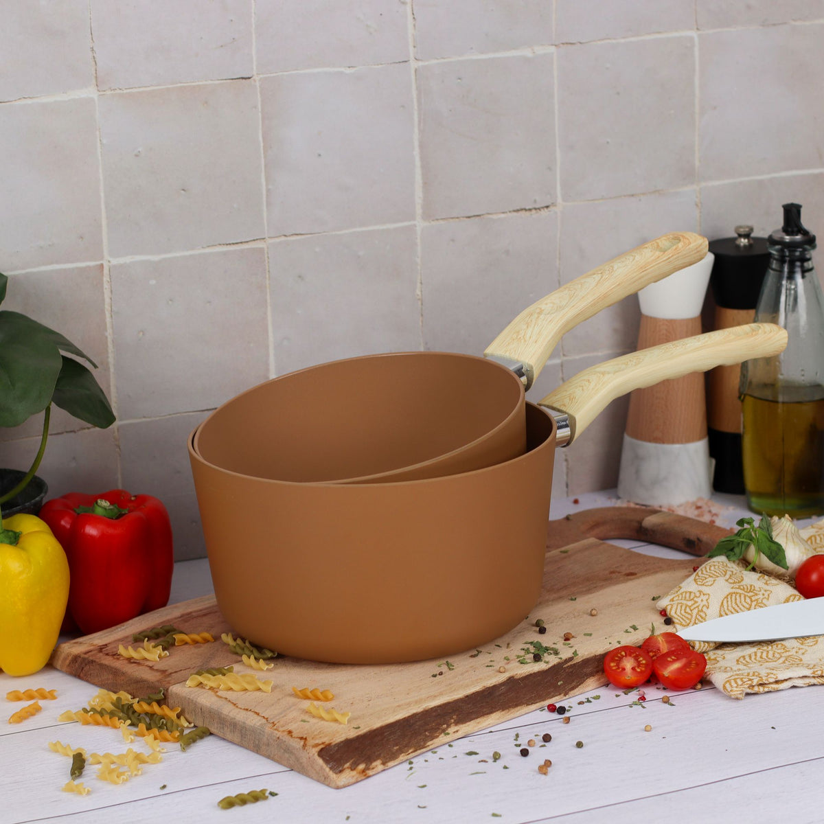 Casserole Colorama 20 cm terracotta avec deux tailles, posée sur planche bois avec légumes et pâtes