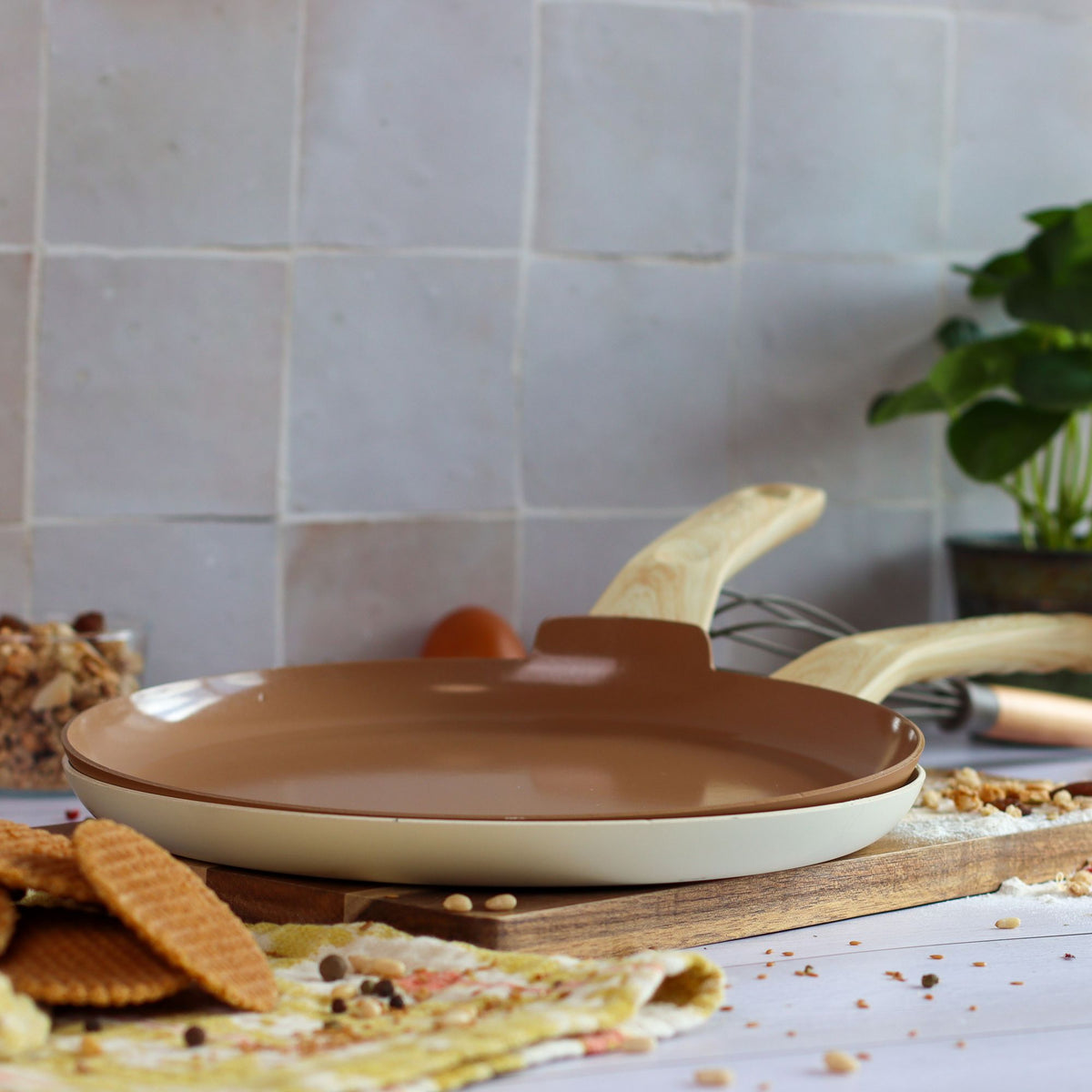 Crêpière Colorama 26 cm beige avec couvercle, posée sur planche bois avec bananes et biscuits