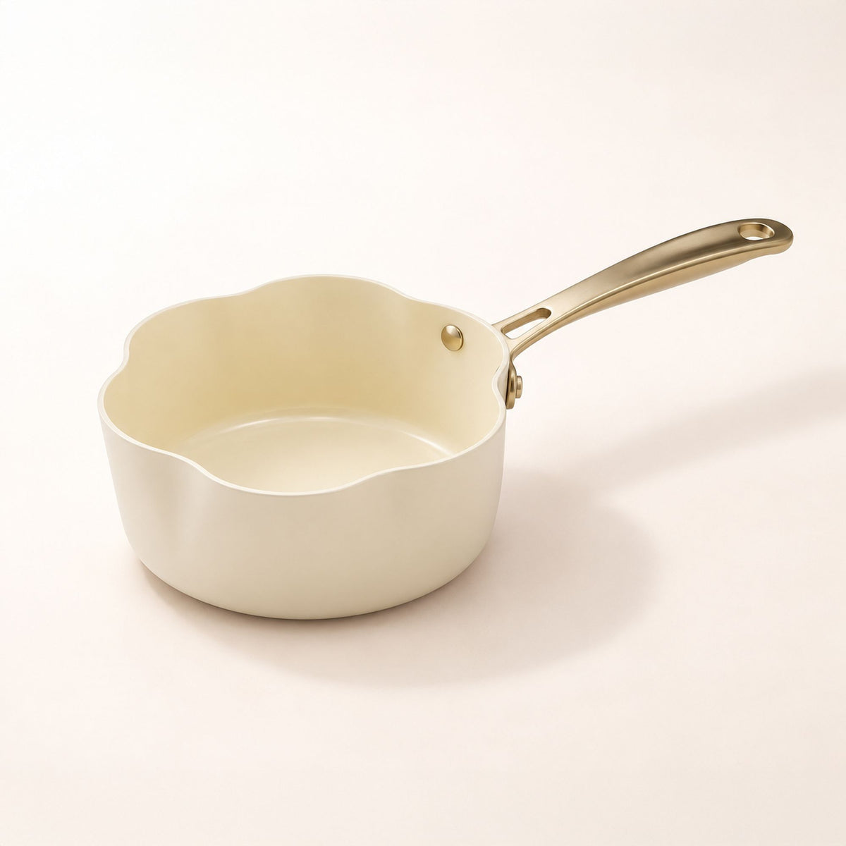 Casserole Dahlia 20 cm beige en aluminium recyclé, vue de trois-quarts avec poignée dorée sur fond blanc