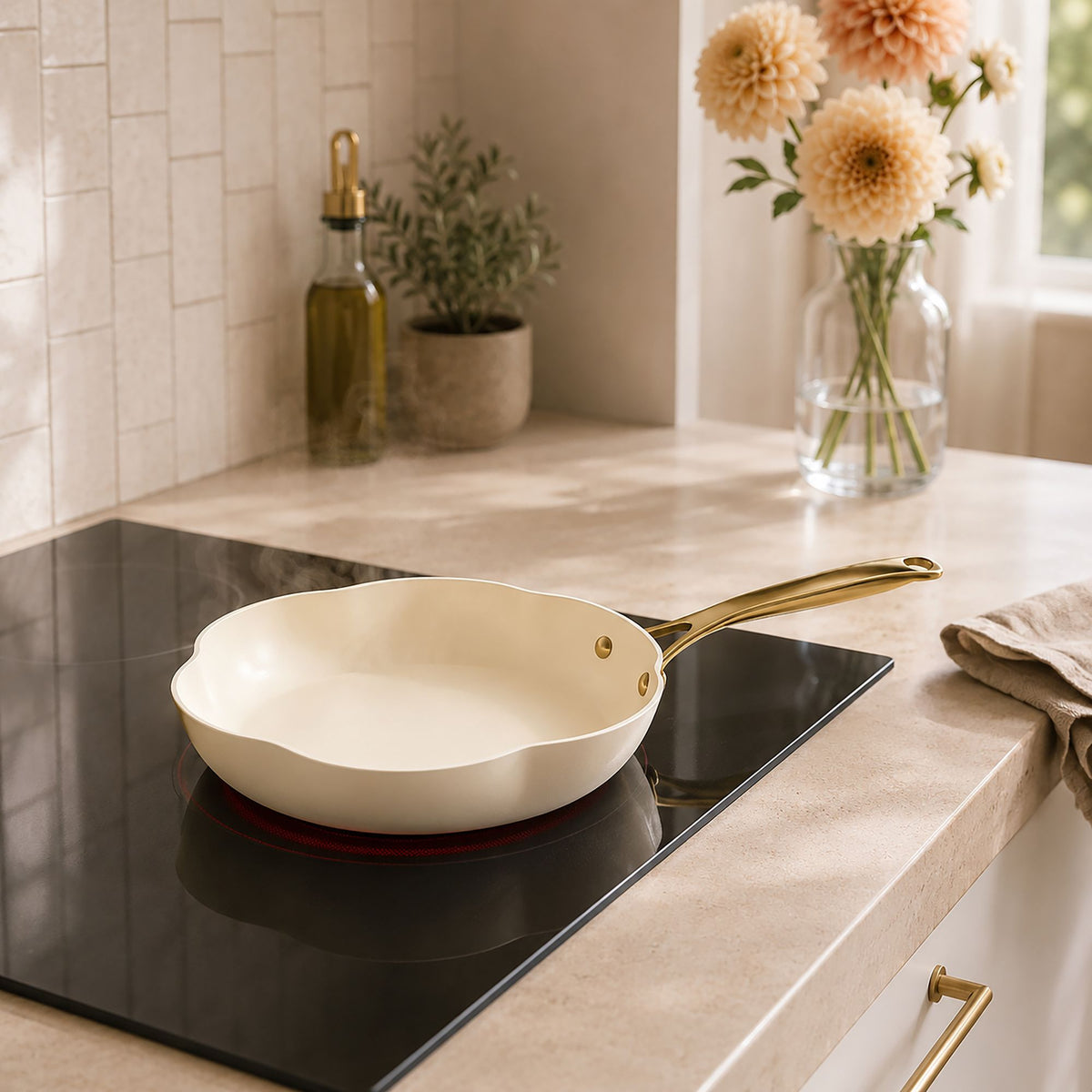 Poêle Dahlia 28 cm beige et dorée sur plaque induction, dans cuisine élégante avec fleurs