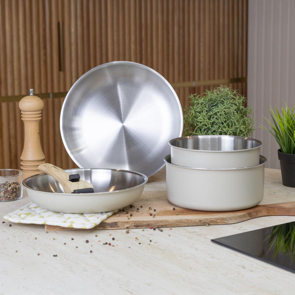 Set de 5 pièces Easynox amovible beige et inox posé sur plan de travail, détail des ustensiles et poignée bois