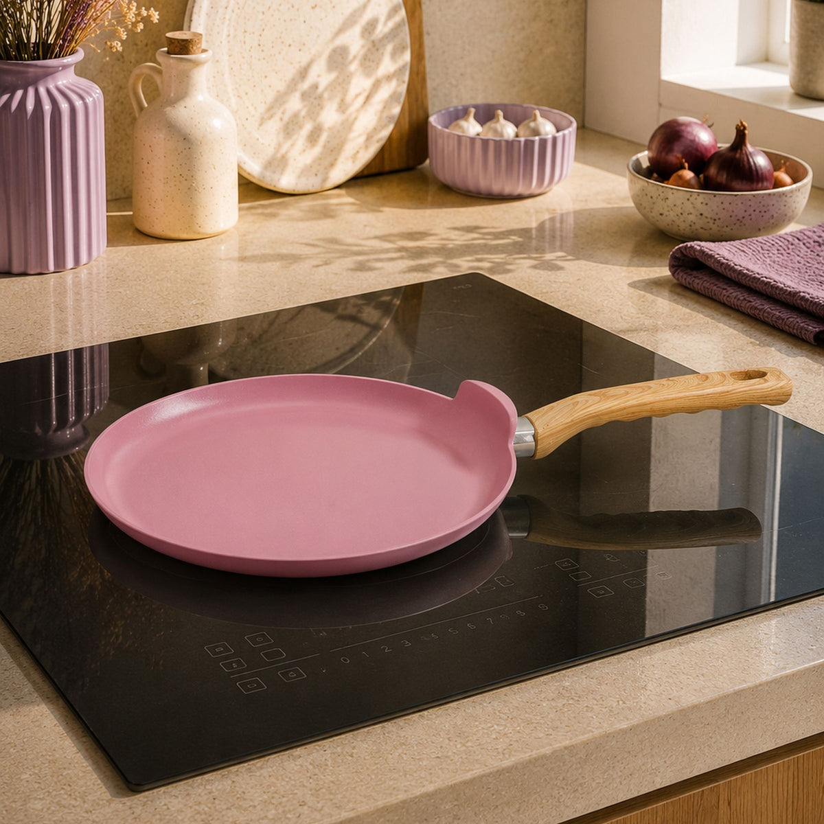 Crêpière Colorama 26 cm rose posée sur plaque induction, comptoir beige avec décoration cuisine tons mauves