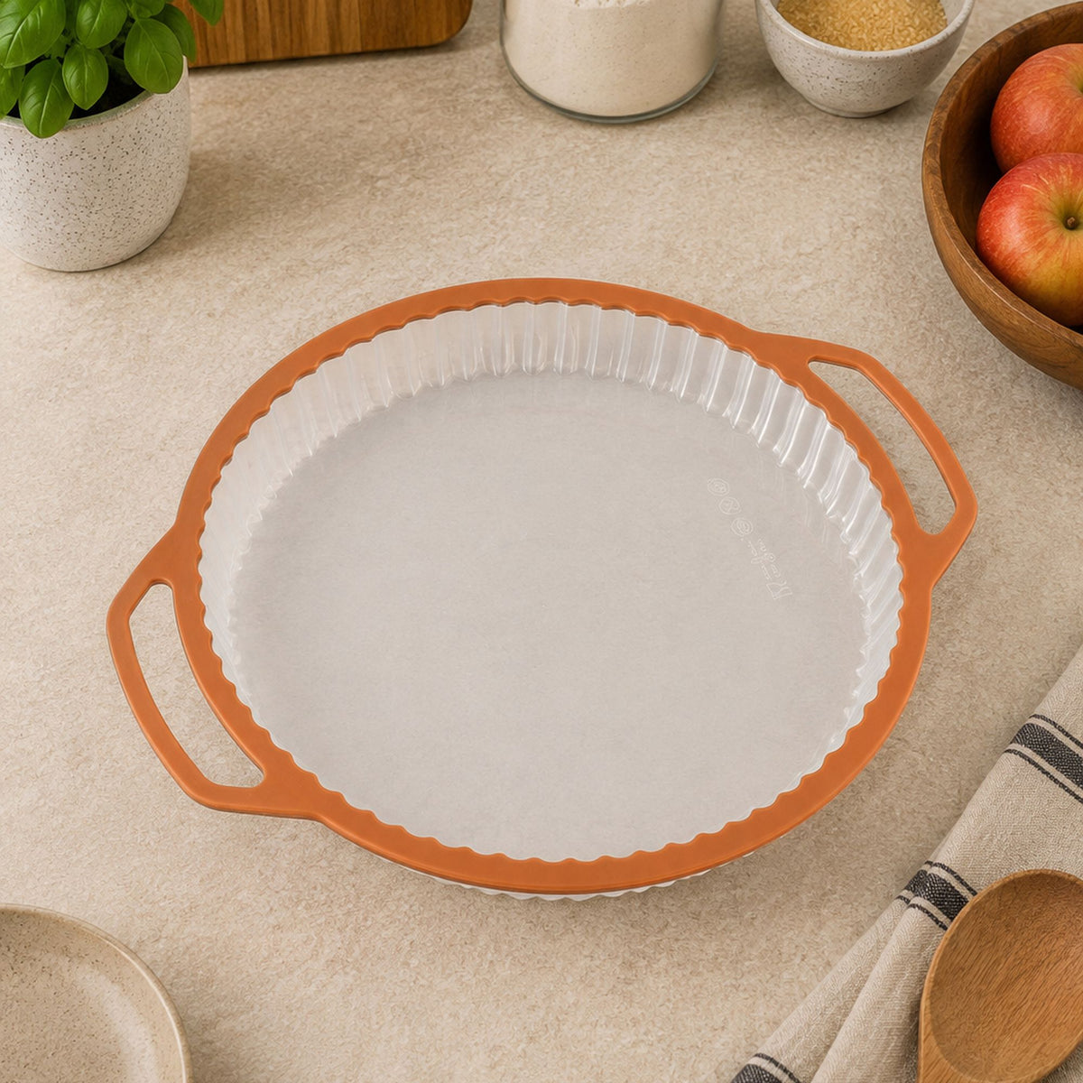 Moule à tarte Mady 26cm en silicone blanc et rebord acier carbone orange, vue de dessus sur plan de travail