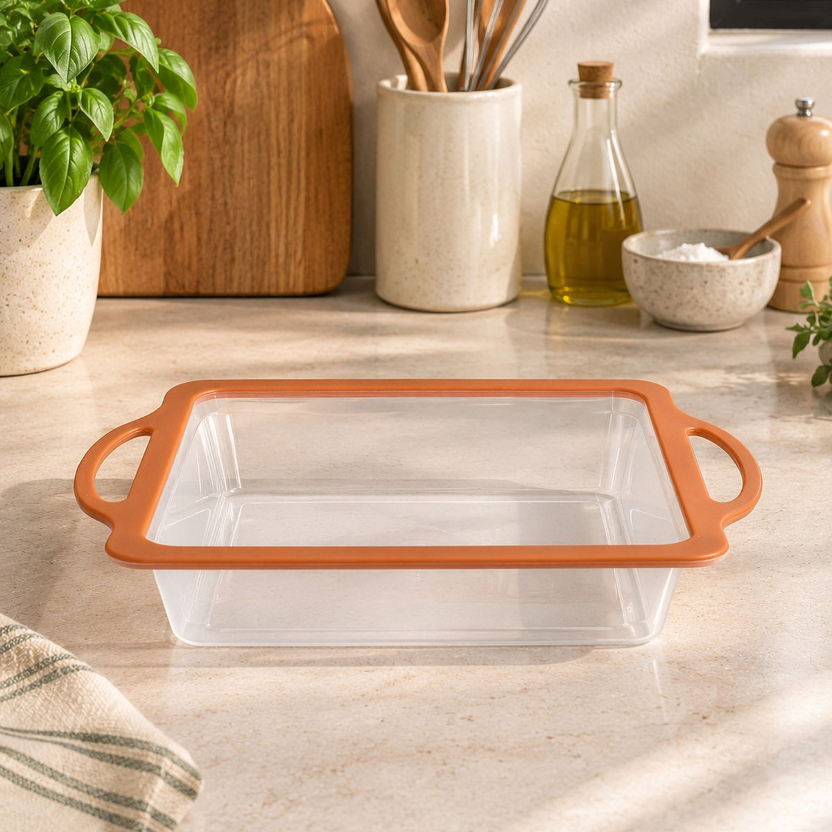 Moule à gâteau carré Mady 23x23cm en silicone orange et acier, posé sur plan de travail cuisine moderne