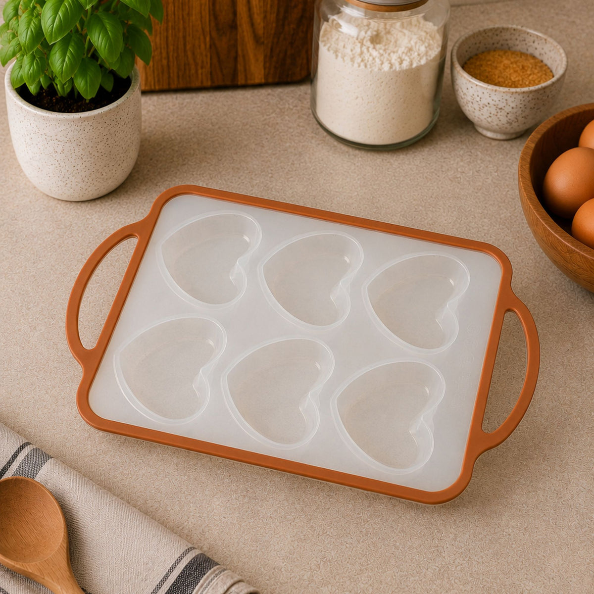 Moule à pâtisserie 6 cœurs silicone et acier, posé sur plan de travail avec ingrédients de cuisine