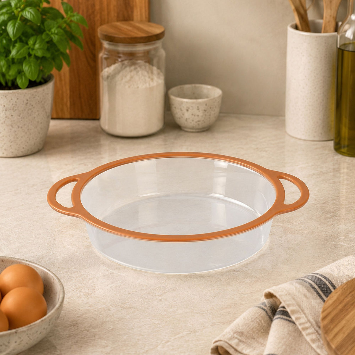 Moule à manqué Mady 24,5cm en silicone et acier carbone avec poignées orange, posé sur plan de travail de cuisine