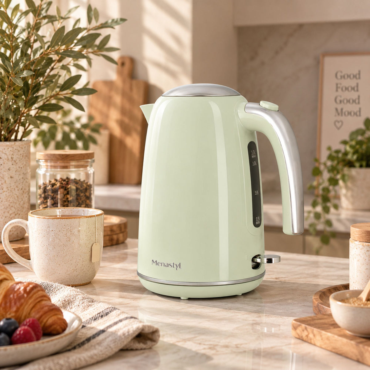 Bouilloire électrique rétro 1,7L vert pastel Menastyl sur plan de travail bois avec tasse et croissants