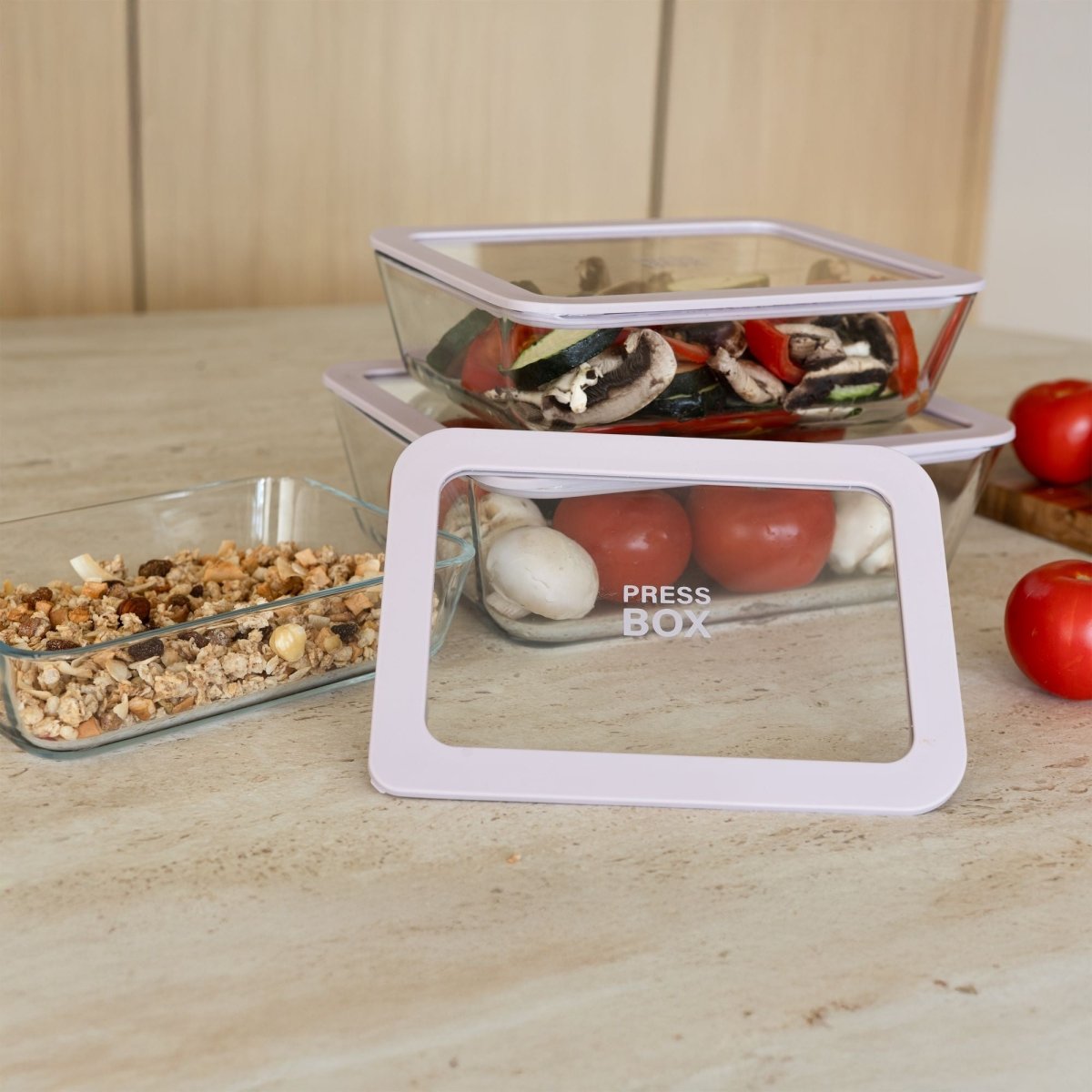 Boîte hermétique rectangulaire Pressbox 820ml en verre borosilicate avec couvercle blanc, empilée sur plan de travail avec légumes