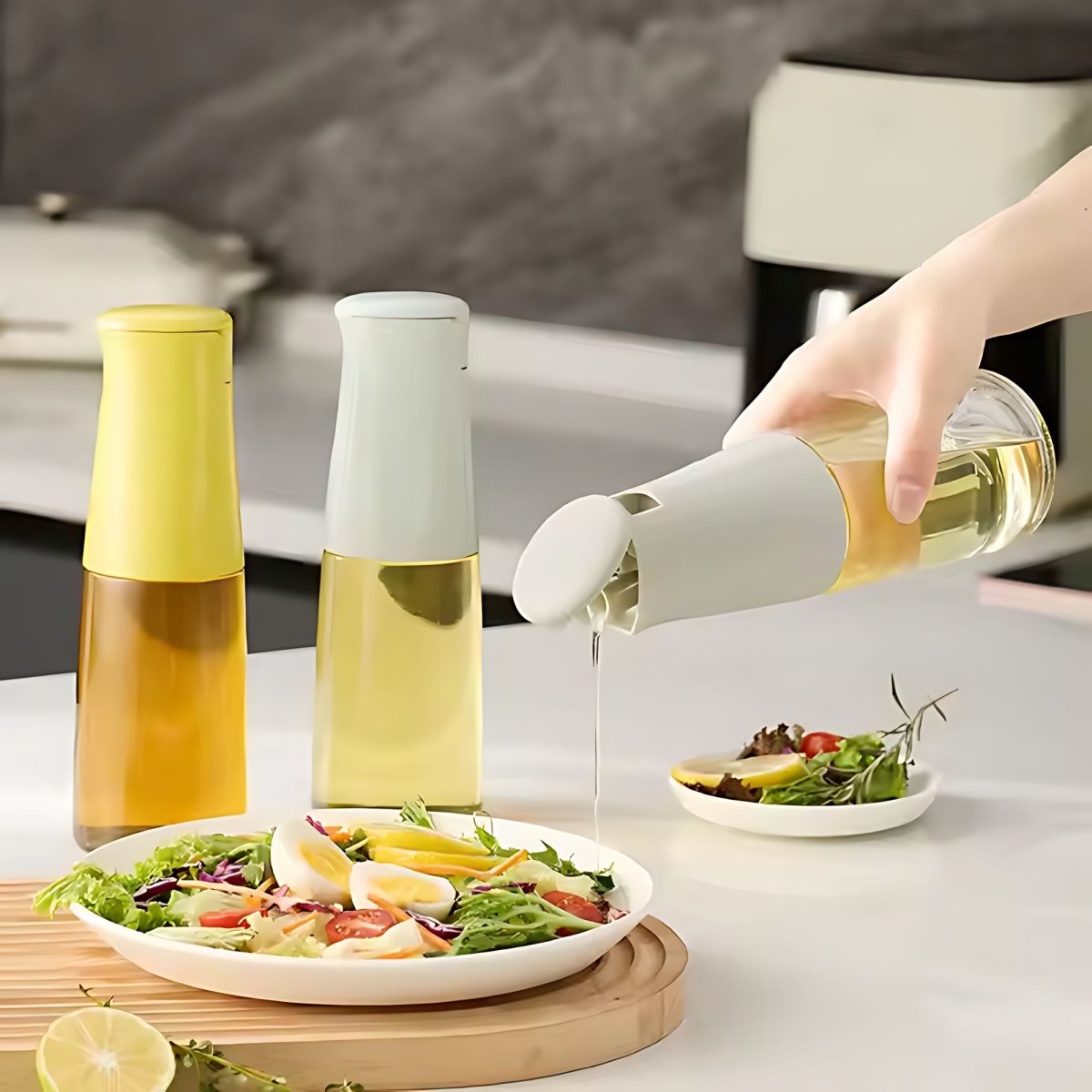 Main versant de l'huile d'une bouteille en verre et plastique blanc sur une salade fraîche, dosage précis