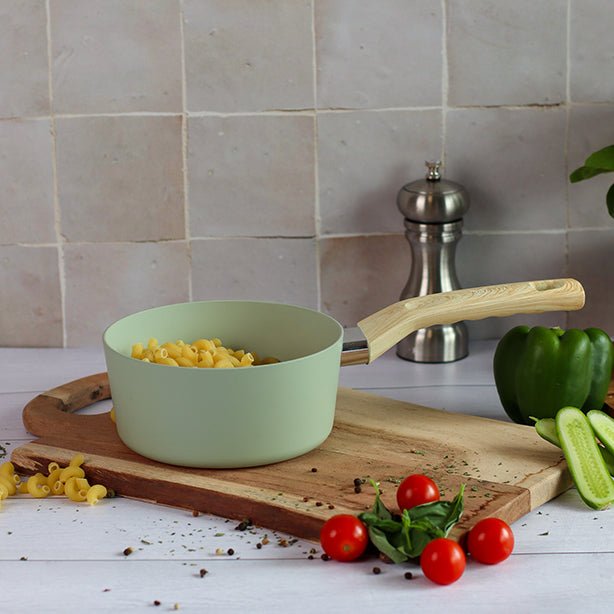 Casserole Colorama 16 cm vert pastel avec pâtes, sur planche bois avec légumes frais en décor cuisine