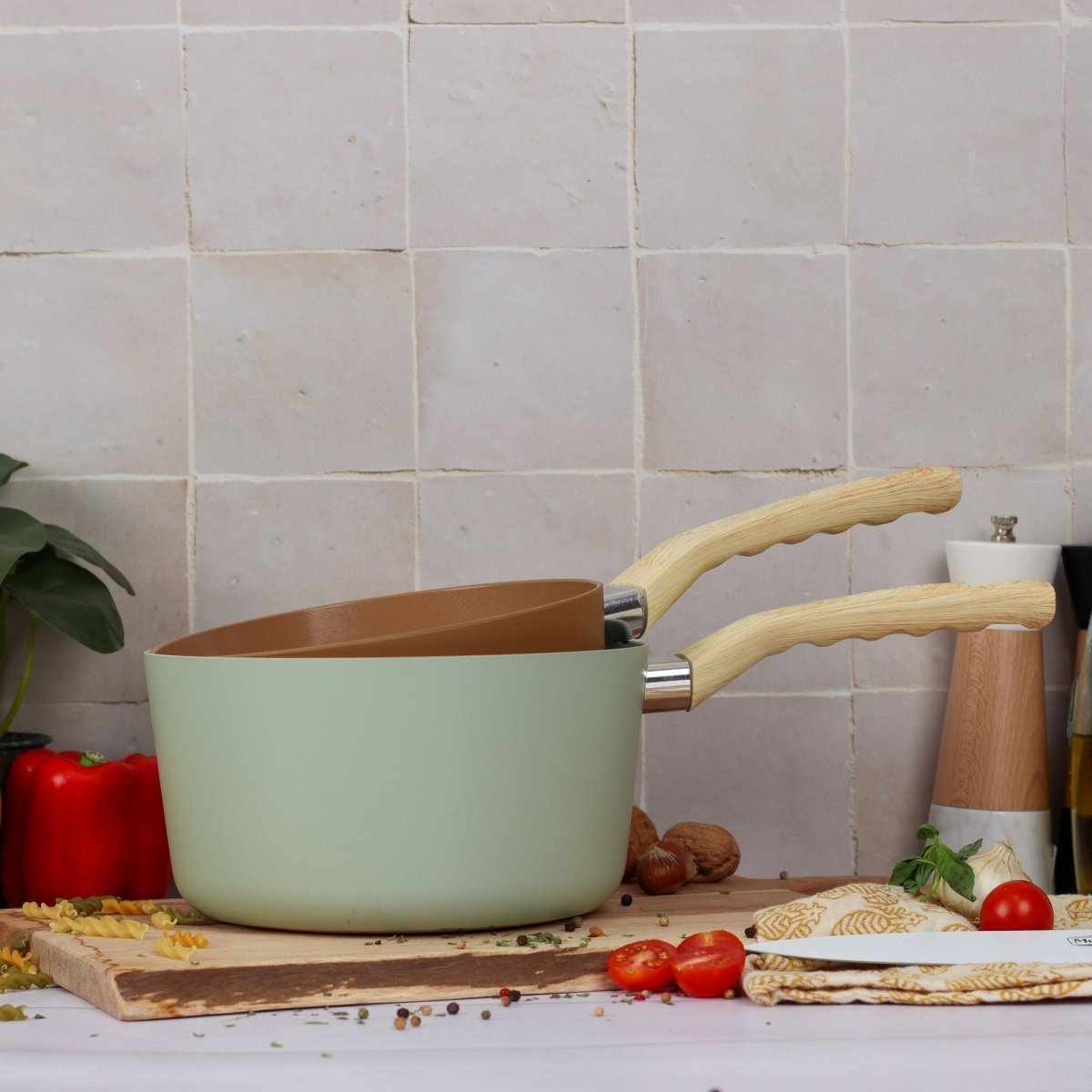 Casserole Colorama 20 cm vert pastel avec intérieur bronze et poignée bois, mise en scène cuisine avec ingrédients