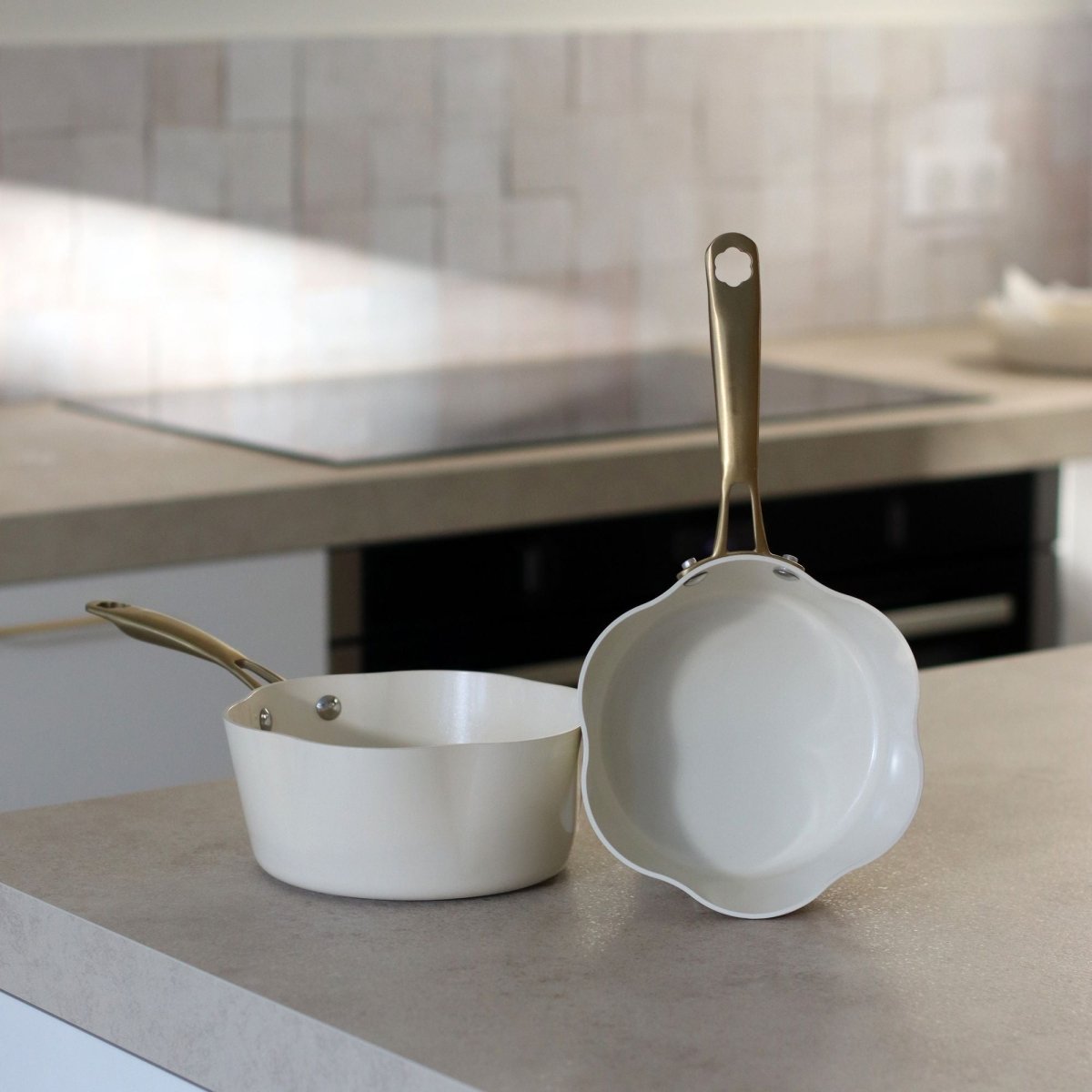 Casserole Dahlia 20 cm blanche et sauteuse assorties posées sur plan de travail de cuisine moderne