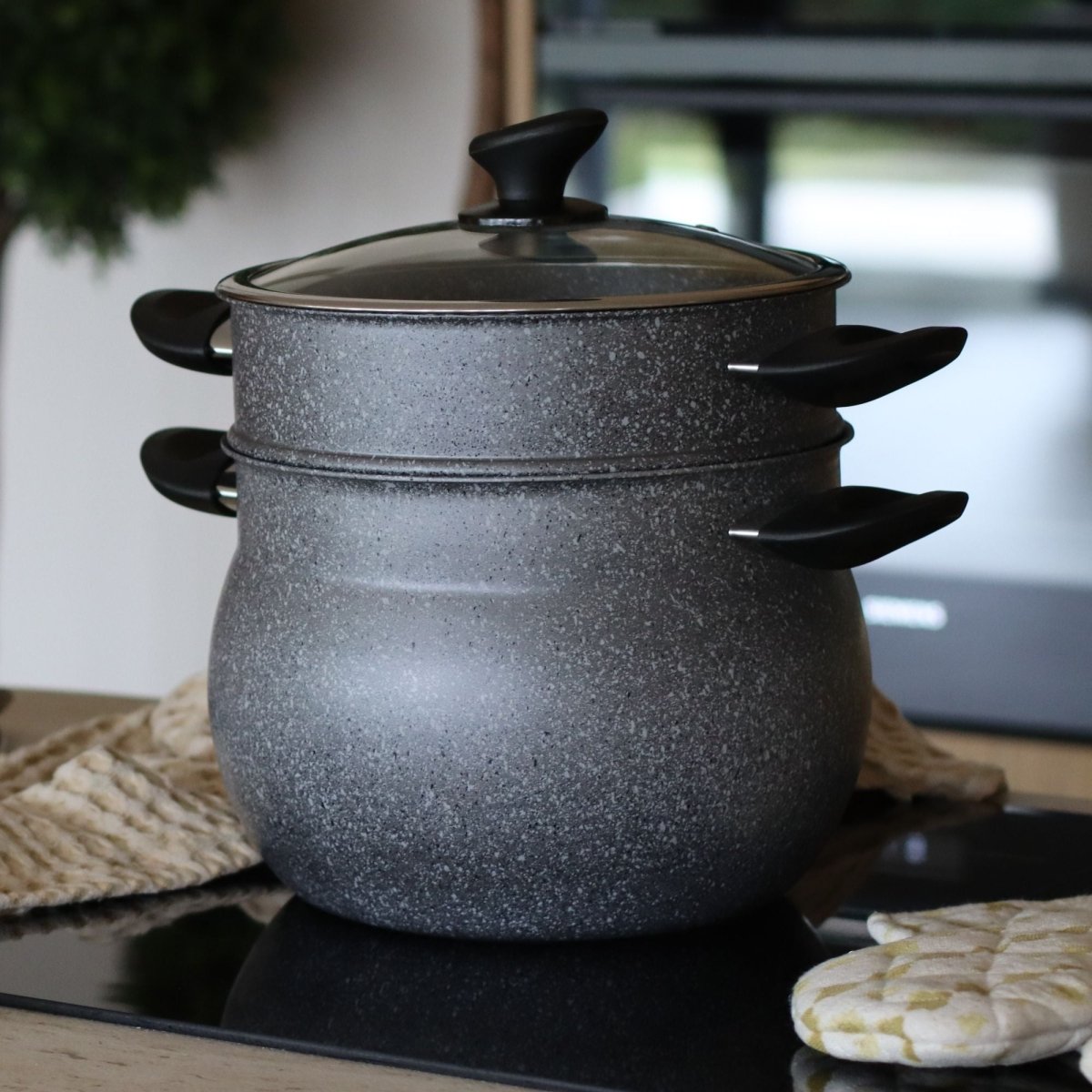 Couscoussier 9L en aluminium gris granité avec double étage et couvercle en verre, posé sur plaque de cuisson