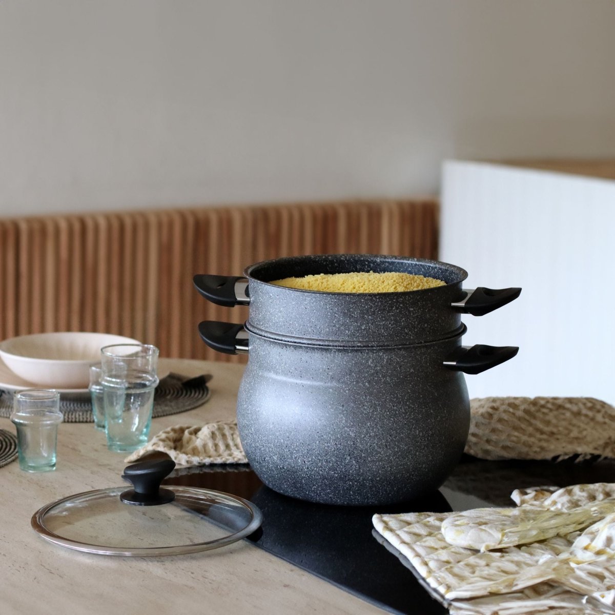 Couscoussier 9L en aluminium noir empilé sur table, vue d'ambiance avec couvercle en verre et vapeur dorée
