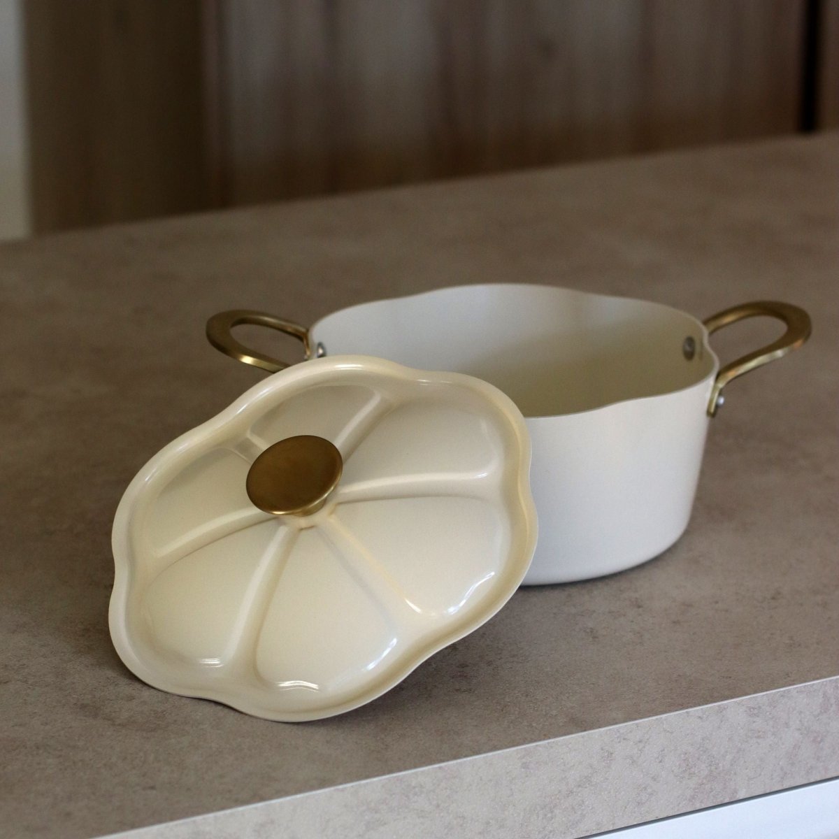 Faitout Dahlia 24 cm beige avec couvercle détaché, anses dorées, vue de dessus sur plan de travail