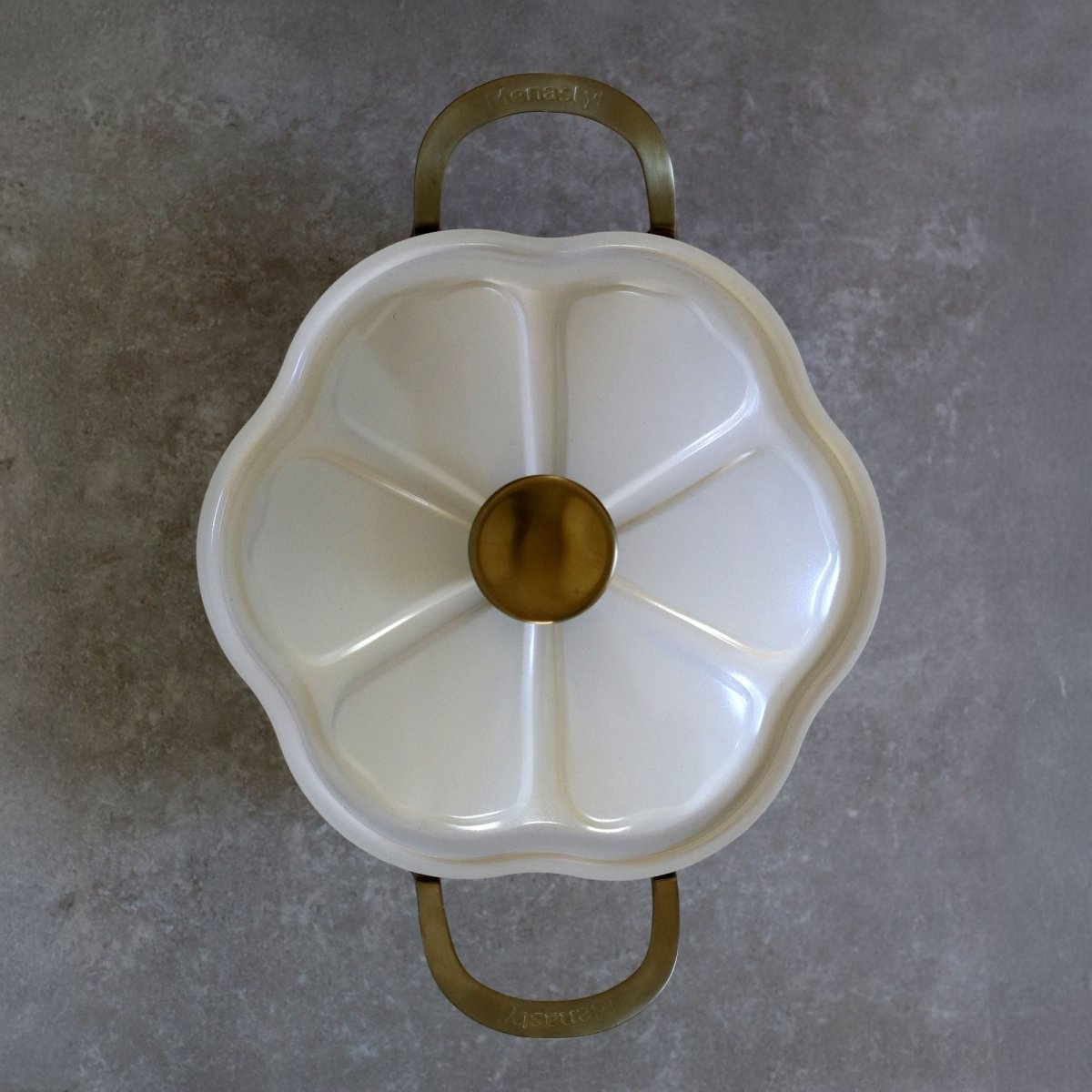 Vue de dessus du faitout Dahlia 24 cm beige avec couvercle en forme de fleur et poignées dorées