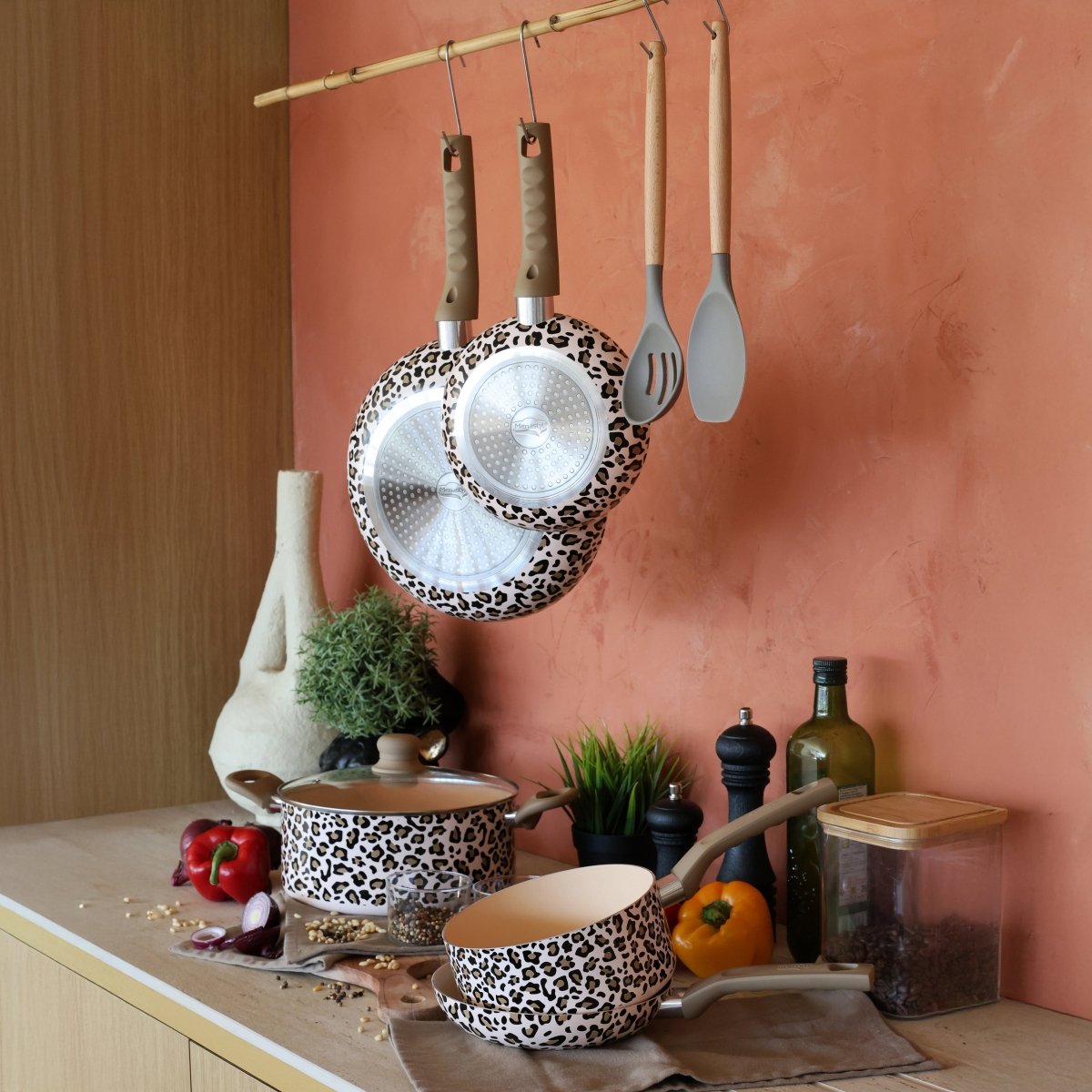 Faitout léopard 24cm avec casseroles et poêles assorties suspendues, mise en scène cuisine avec légumes et accessoires