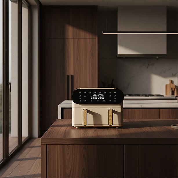 Friteuse à air chaud double cuve coloris crème et doré, posée sur îlot de cuisine en bois dans intérieur moderne