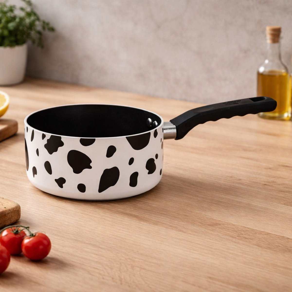 Casserole motif vache blanc et noir en aluminium avec revêtement céramique, posée sur plan de travail bois clair