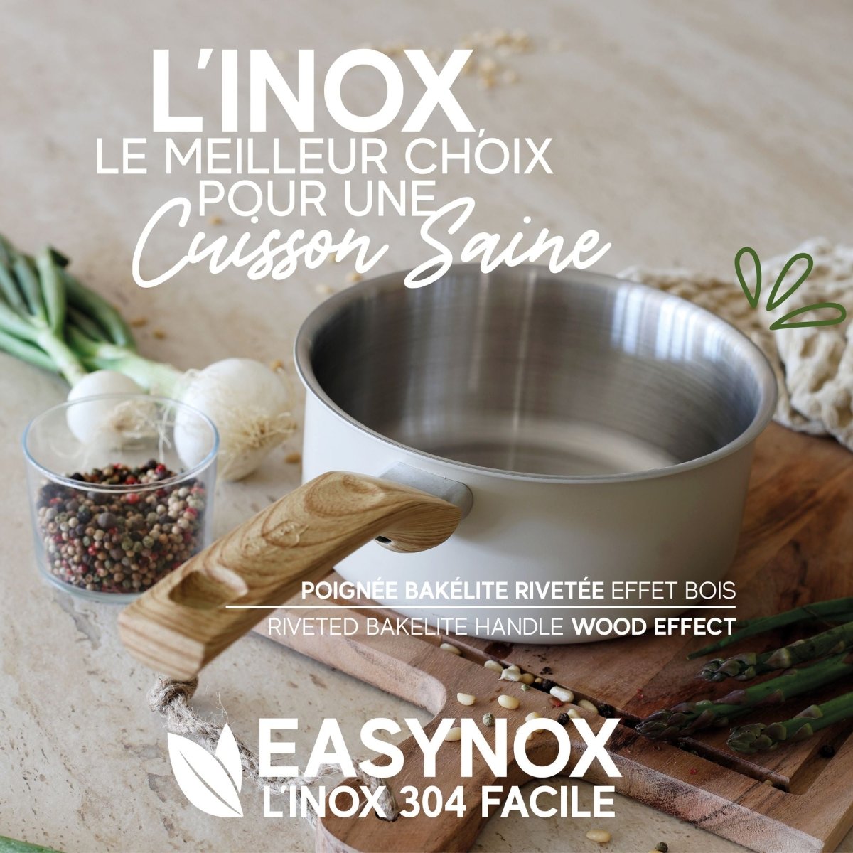 Casserole inox avec poignée bakélite effet bois, mise en scène culinaire avec ingrédients sur plan de travail