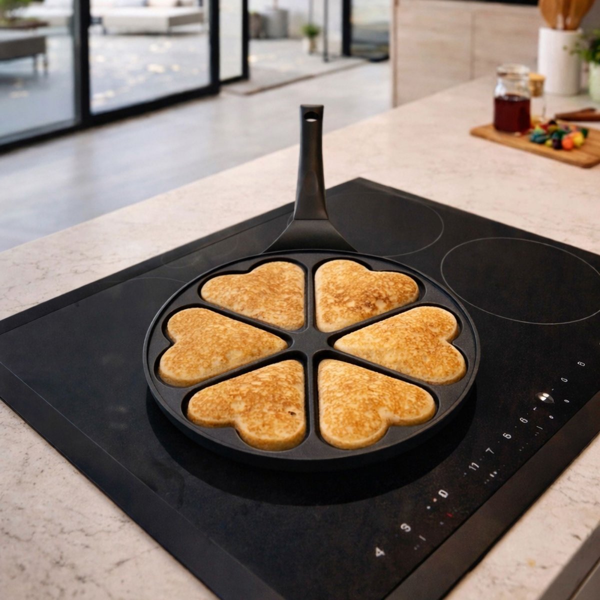 Poêle à pancakes cœur 26cm en aluminium noir avec 6 pancakes dorés sur plaque induction moderne