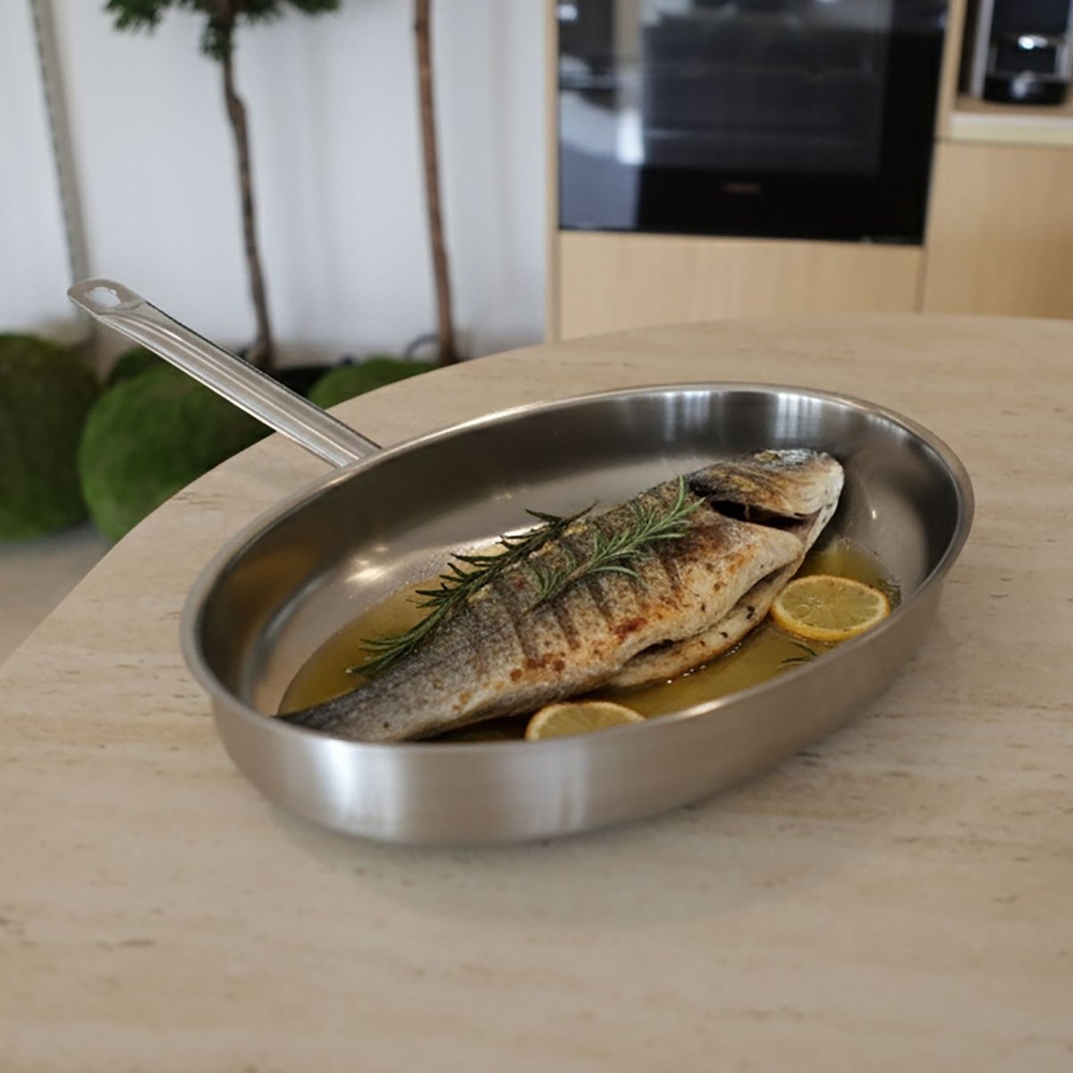 Poêle à poisson ovale 37,5cm en inox avec dorade grillée, romarin et citron sur table en bois