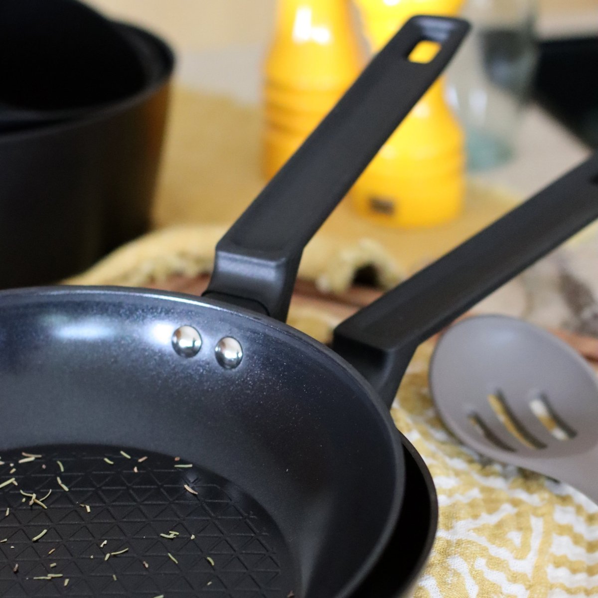 Poêle First 26 cm noire avec spatule, vue d'ensemble sur plan de travail cuisine