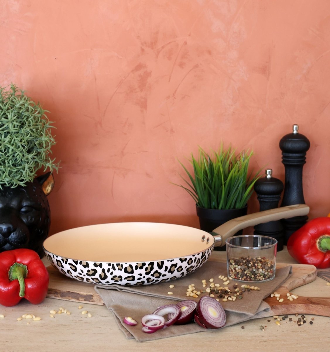 Poêle Léopard 24cm motif léopard marron et beige, mise en scène cuisine avec légumes et épices sur plan de travail