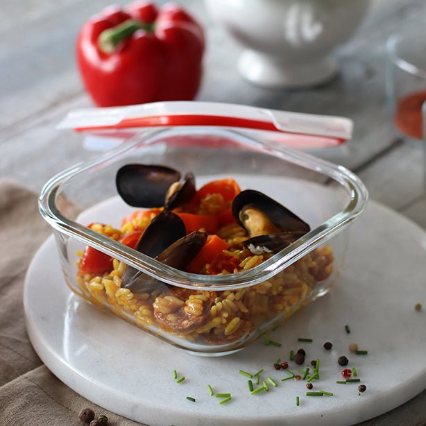 Boîte hermétique en verre borosilicate contenant paella aux moules et poivrons, couvercle rouge entrouvert