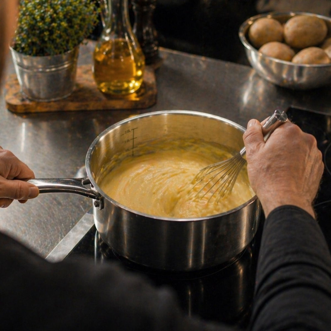 Casserole Triply en préparation d'une sauce onctueuse, fouet en action sur plaque induction