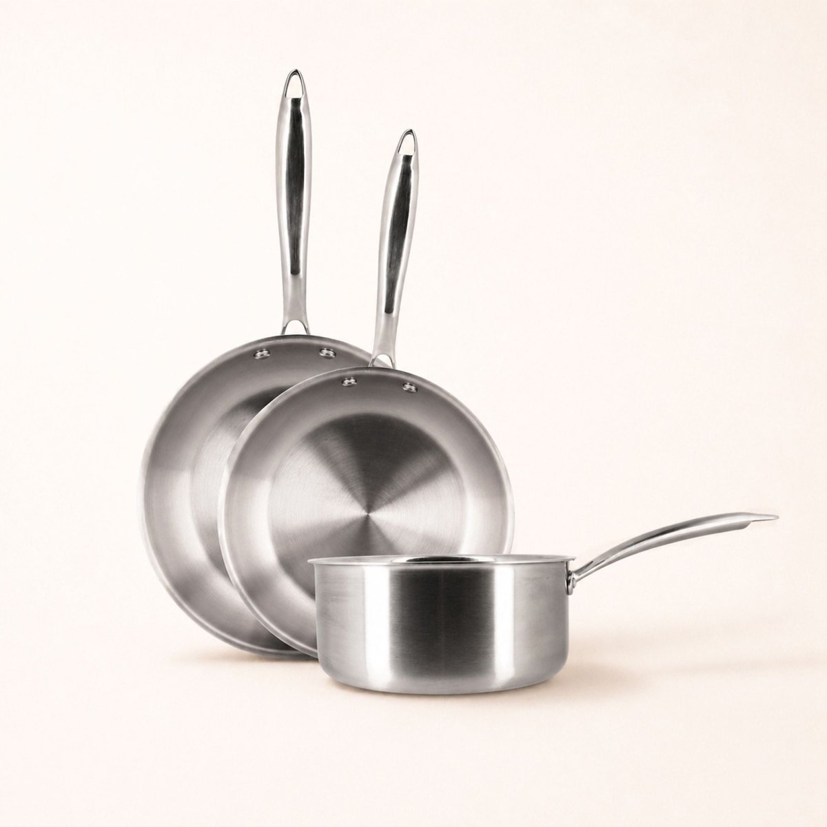 Set de 3 pièces Triply Menastyl en acier inoxydable : 2 poêles et 1 casserole, vue d'ensemble sur fond clair