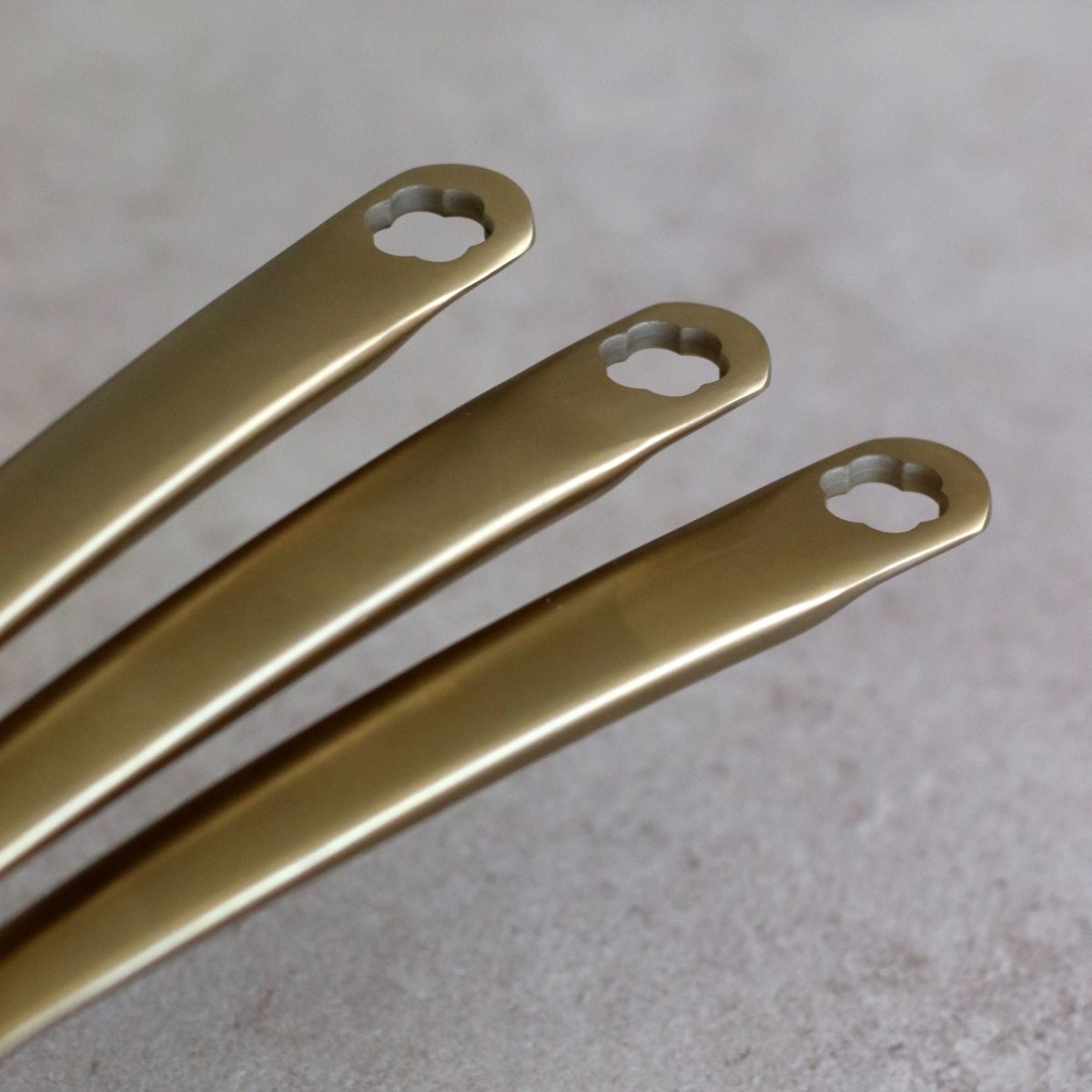 Détail des spatules dorées en aluminium recyclé beige du set 5 pièces Dahlia, finition mate et élégante