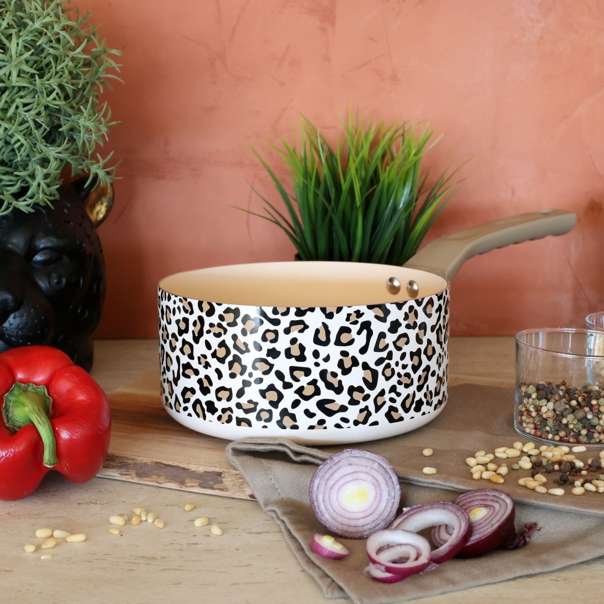 Casserole motif léopard marron avec décor animalier, mise en scène cuisine avec légumes et épices sur plan de travail