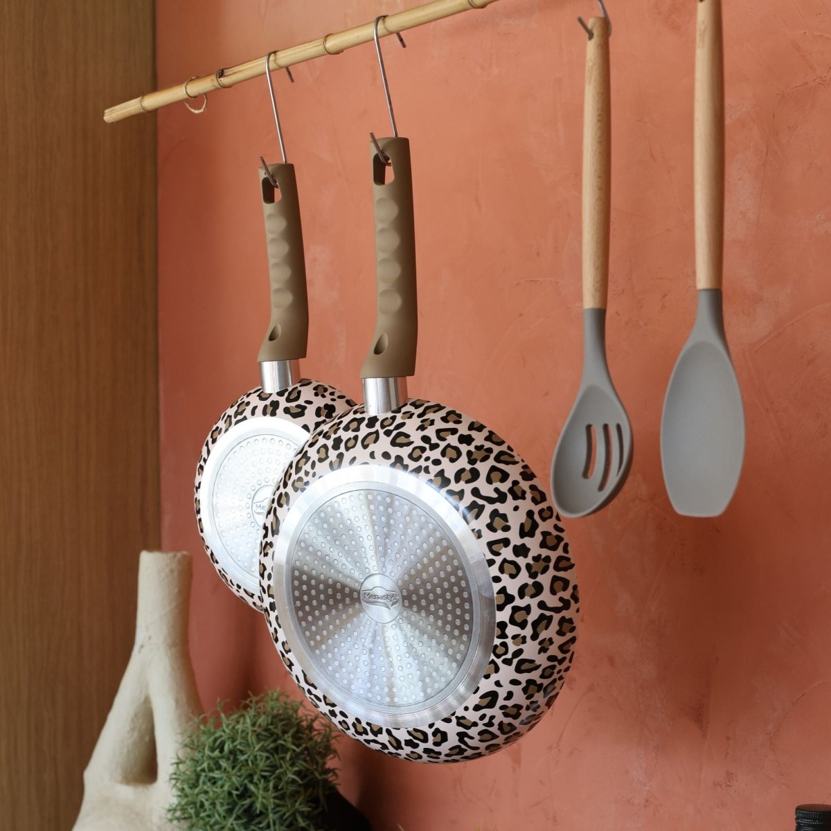Set de 5 pièces Léopard avec poêles motif léopard suspendues et spatules grises sur fond terracotta