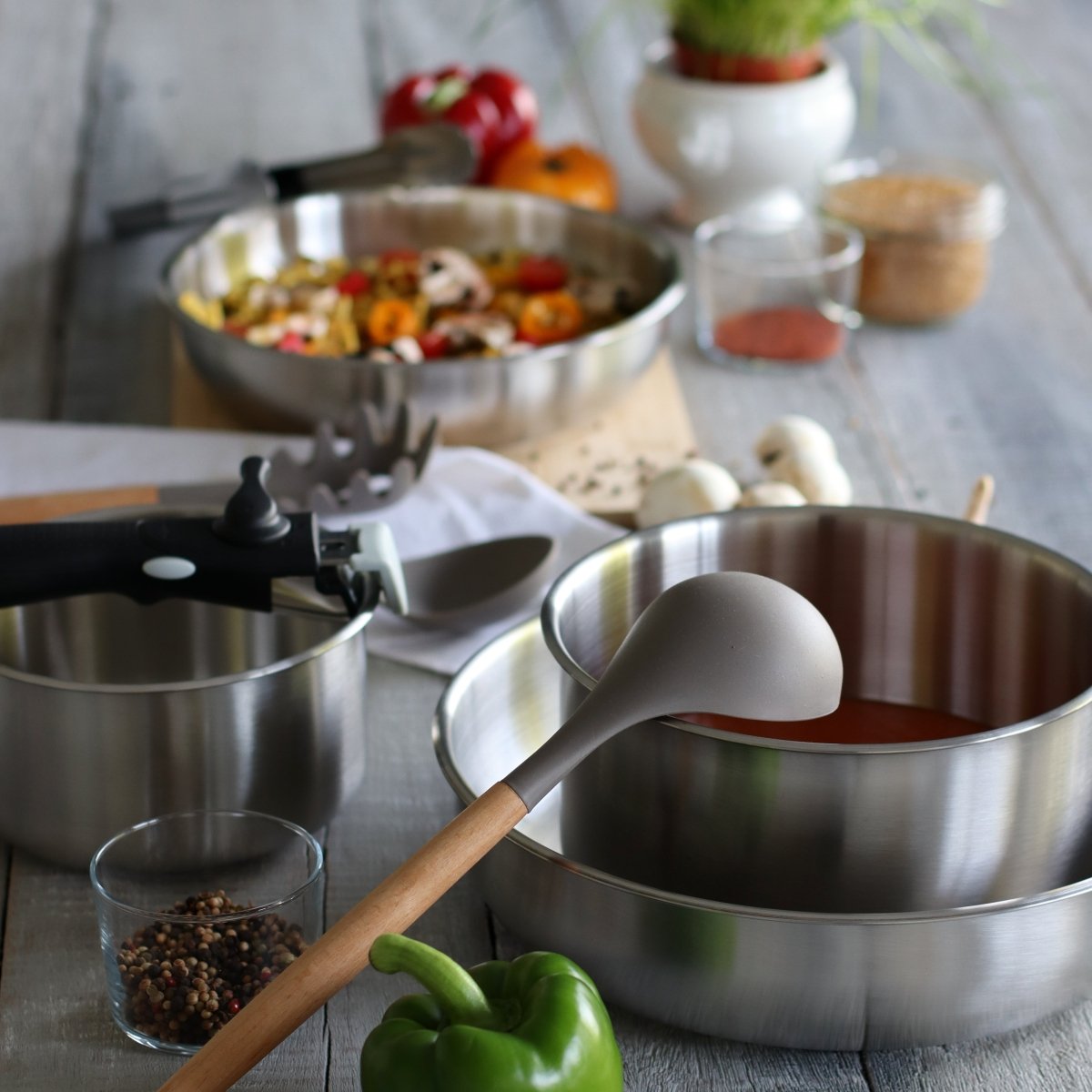Set de 8 pièces Iris en acier inoxydable avec casseroles, poêles et poignées amovibles, préparation culinaire en cours