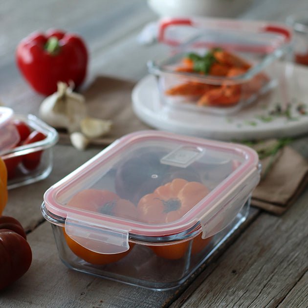 Boîte hermétique rectangulaire 630ml en verre avec joint rouge, disposée sur table en bois avec légumes frais