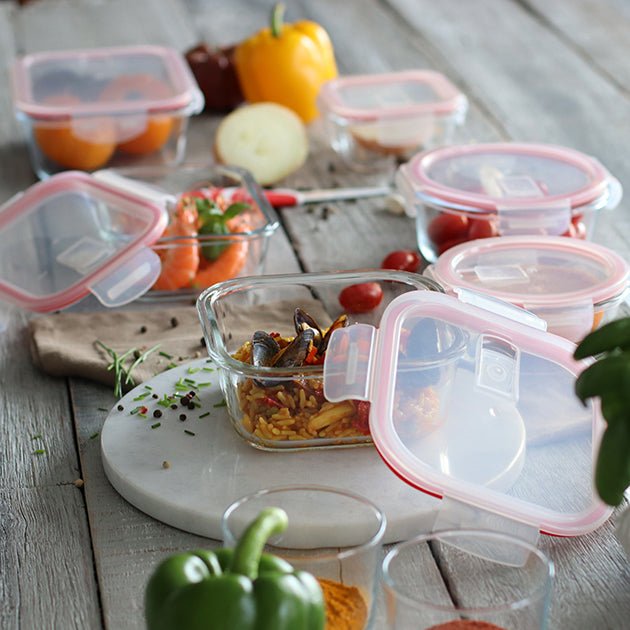 Set de boîtes hermétiques en verre avec couvercles transparents contenant légumes et aliments colorés sur table en bois
