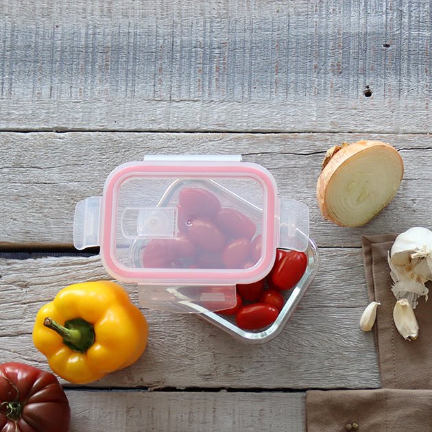 Boîte hermétique transparente avec légumes frais, vue détaillée du couvercle rose et découpe d'oignon sur planche